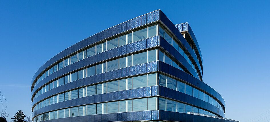 Das Gebäude schimmert blau dank des eingefärbten Rückglases. Bild: David Yela, The Setrunners GmbH