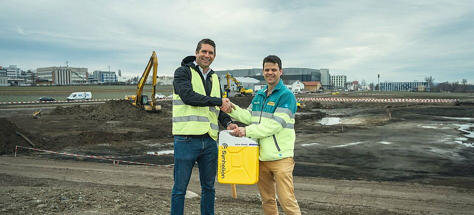(v.l.n.r) Philipp Furler (Co-CEO und Mitgründer von Synhelion) und Silvan Eberhard (Leiter Logistik bei Eberhard Unternehmungen) feiern die Vereinbarung über den Abnahmevertrag für Solardiesel für Baumaschinen. Bild: Synhelion AG