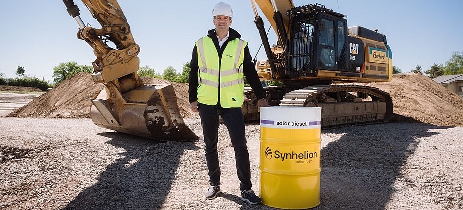Co-CEO und Mitbegründer von Synhelion Philipp Furler steht vor dem Bagger von Eberhard, der mit dem synthetischen Diesel von Synhelion betrieben wird. Bild: Synhelion AG