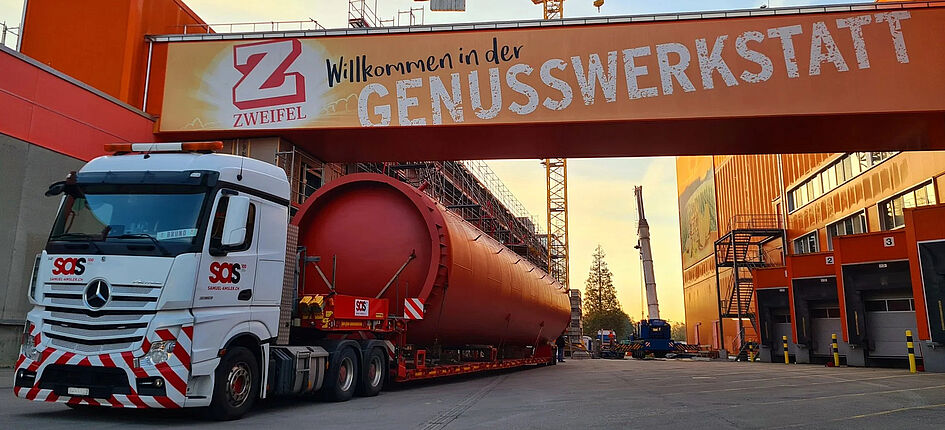 Der 25 Meter hohe Pufferspeicher wurde im Nacht-Transport angeliefert. Bild: Jenni Energietechnik AG, Zweifel Chips & Snacks AG, Peter Warthmann, HK Gebäudetechnik